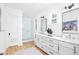 Bright bathroom featuring a glass shower, dual sinks, white cabinets, and sleek black hardware at 202 Bank St, Mount Pleasant, SC 29464
