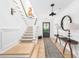 Inviting foyer with a staircase, dark front door, and a table with decorative lamps at 202 Bank St, Mount Pleasant, SC 29464
