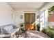 Inviting front porch with brick flooring, seating, and plants with lovely double doors at 202 Bank St, Mount Pleasant, SC 29464