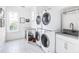 Bright laundry room featuring stacked washer and dryer, patterned tile floor, and a sink with gray countertop at 202 Bank St, Mount Pleasant, SC 29464