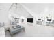 Large living room with vaulted ceiling, a plush sofa, a TV, a desk, and bright natural light at 202 Bank St, Mount Pleasant, SC 29464