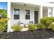 Cozy front porch features charming seating, complemented by fresh landscaping and a welcoming entryway at 203 Yeamans Way, Summerville, SC 29483