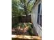 Partially overgrown side yard featuring a wooden fence and mature shade trees, enhancing privacy at 2041 Covey Ln, Charleston, SC 29412
