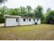 Rear view of house with simple white siding, an air conditioning unit, and green grass at 208 Orange St, Walterboro, SC 29488