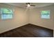 Bright bedroom features modern ceiling fan, updated flooring and white trim around dual windows at 208 Orange St, Walterboro, SC 29488