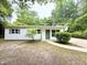 Charming single-story home with vinyl siding and a welcoming front entrance, nestled in a lush, wooded setting at 208 Orange St, Walterboro, SC 29488
