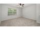 Neutral bedroom featuring neutral carpet, ceiling fan, and large window at 215 Jackson St, Goose Creek, SC 29445