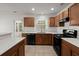 Modern kitchen with stainless steel appliances, wooden cabinets, and island with white countertops at 215 Jackson St, Goose Creek, SC 29445
