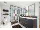 Bright bathroom featuring double sinks, black vanity, black and white backsplash, and glass shower at 2363 Palmer Creek Bnd, Charleston, SC 29412