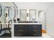 Bright bathroom featuring double sinks, black vanity, black and white backsplash, and glass shower at 2363 Palmer Creek Bnd, Charleston, SC 29412