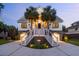 Stunning two-story home with dual staircases, lush landscaping, and palm trees at 2363 Palmer Creek Bnd, Charleston, SC 29412