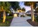 Charming exterior of a raised beach house with well-lit palm trees, and a spacious driveway at 2363 Palmer Creek Bnd, Charleston, SC 29412