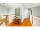 Hallway featuring hardwood floors, white railings, and a large painting of a heron at 2363 Palmer Creek Bnd, Charleston, SC 29412