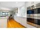 A well lit kitchen with stainless steel appliances, white cabinetry, and hardwood floors at 2363 Palmer Creek Bnd, Charleston, SC 29412