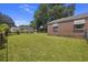 Spacious backyard with lush grass, mature trees, and brick exterior at 2703 Phyllis St, North Charleston, SC 29405