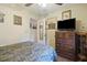 Bedroom featuring vintage dresser, TV, wood floors, and camouflage-patterned bedding for a rustic feel at 2703 Phyllis St, North Charleston, SC 29405