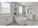 Elegant bathroom with a soaking tub, white cabinets and countertop, large mirror, and natural light at 2917 River Vista Way, Mount Pleasant, SC 29466