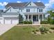 Charming two-story home with a welcoming front porch and a nicely landscaped front yard with palm trees and shrubs at 2917 River Vista Way, Mount Pleasant, SC 29466