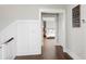 Hallway view to a bedroom with hardwood floors, board and batten wall paneling, and neutral paint at 2917 River Vista Way, Mount Pleasant, SC 29466
