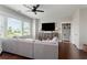 Bright living room features a ceiling fan and a comfortable sectional sofa with abundant natural light from the large window at 2917 River Vista Way, Mount Pleasant, SC 29466