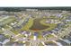 Aerial view of the neighborhood showcasing homes around a pond and lush greenery at 302 Lucca Dr, Summerville, SC 29486