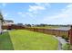 Well-manicured backyard with lush grass, a privacy fence, and patio area with an umbrella-covered table at 302 Lucca Dr, Summerville, SC 29486