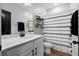 Modern bathroom featuring a white vanity, industrial shelving, and stylish striped shower curtain at 302 Lucca Dr, Summerville, SC 29486