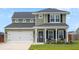 Attractive two-story home with a covered porch, well-kept lawn, and a two-car garage at 302 Lucca Dr, Summerville, SC 29486
