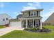 Charming two-story home with manicured front yard, green lawn, and covered front porch at 302 Lucca Dr, Summerville, SC 29486