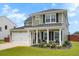 Charming two-story home with manicured front yard, green lawn, and covered front porch at 302 Lucca Dr, Summerville, SC 29486