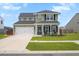 Charming two-story home with manicured front yard, green lawn, and covered front porch at 302 Lucca Dr, Summerville, SC 29486