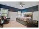 Spacious main bedroom with blue accent wall, two windows, ceiling fan, and reading chair at 3025 Rampart Rd, Summerville, SC 29483