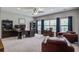Well-lit office with two windows, ceiling fan, desk with monitors, bookshelves and leather furniture at 3025 Rampart Rd, Summerville, SC 29483