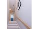 Bright staircase featuring white risers, wooden treads, and a natural wood handrail with decor at 3025 Rampart Rd, Summerville, SC 29483