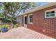 Back of brick house with wood deck, exterior lighting, and access to fenced backyard at 31 Lyttleton St, Charleston, SC 29407
