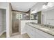 Updated bathroom featuring double vanity, granite counters, white cabinets, and glass enclosed shower at 31 Lyttleton St, Charleston, SC 29407