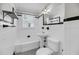 Classic white bathroom featuring a tub, pedestal sink, and toilet, adorned with black and white tile accents at 31 Lyttleton St, Charleston, SC 29407