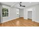 Sunlit bedroom showcasing hardwood floors, dual windows, a dark ceiling fan, and closet with bifold doors at 31 Lyttleton St, Charleston, SC 29407
