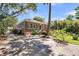 Exterior view of brick house featuring large concrete driveway, mature trees, and manicured landscaping at 31 Lyttleton St, Charleston, SC 29407