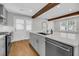 Bright kitchen features a stainless steel sink, white quartz countertops, a stainless steel dishwasher, and wooden support beams at 31 Lyttleton St, Charleston, SC 29407
