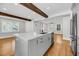 Open concept kitchen with a central island, stainless steel appliances, hardwood floors, and exposed wood beams at 31 Lyttleton St, Charleston, SC 29407