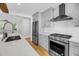 Well-lit kitchen featuring stainless steel appliances, light grey cabinetry, a quartz countertop, and wood flooring at 31 Lyttleton St, Charleston, SC 29407