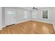 Bright living room with hardwood floors, white walls, large windows, and a door for natural light and access at 31 Lyttleton St, Charleston, SC 29407