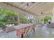 Covered porch featuring a dining table, comfortable lounge furniture and views of the lush landscaping at 312 Hobcaw Dr, Mount Pleasant, SC 29464