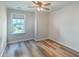 Bright bedroom with wood-look floors, a ceiling fan, and a window offering neighborhood views at 313 Lanyard St, Johns Island, SC 29455