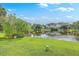 Well-manicured lawn and pond that is surrounded by residential buildings, trees, and blue skies at 313 Lanyard St, Johns Island, SC 29455