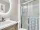 Modern bathroom with a round mirror, vanity, and a glass shower door at 334 Water Oak Dr, Goose Creek, SC 29445