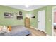 Well-lit bedroom featuring green walls, hardwood floors, and a white door at 334 Water Oak Dr, Goose Creek, SC 29445