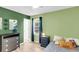 Bright bedroom featuring light green walls, wood floors, and a window with navy curtains at 334 Water Oak Dr, Goose Creek, SC 29445