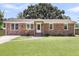 Charming brick home featuring a manicured lawn, inviting walkway, and classic architectural details at 334 Water Oak Dr, Goose Creek, SC 29445